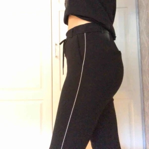  - Svarta byxor med vitt streck på sidorna. Köpt från Only. Använda några gånger men inte många. Storlek M men ganska korta i längden på mig som är 175cm. 