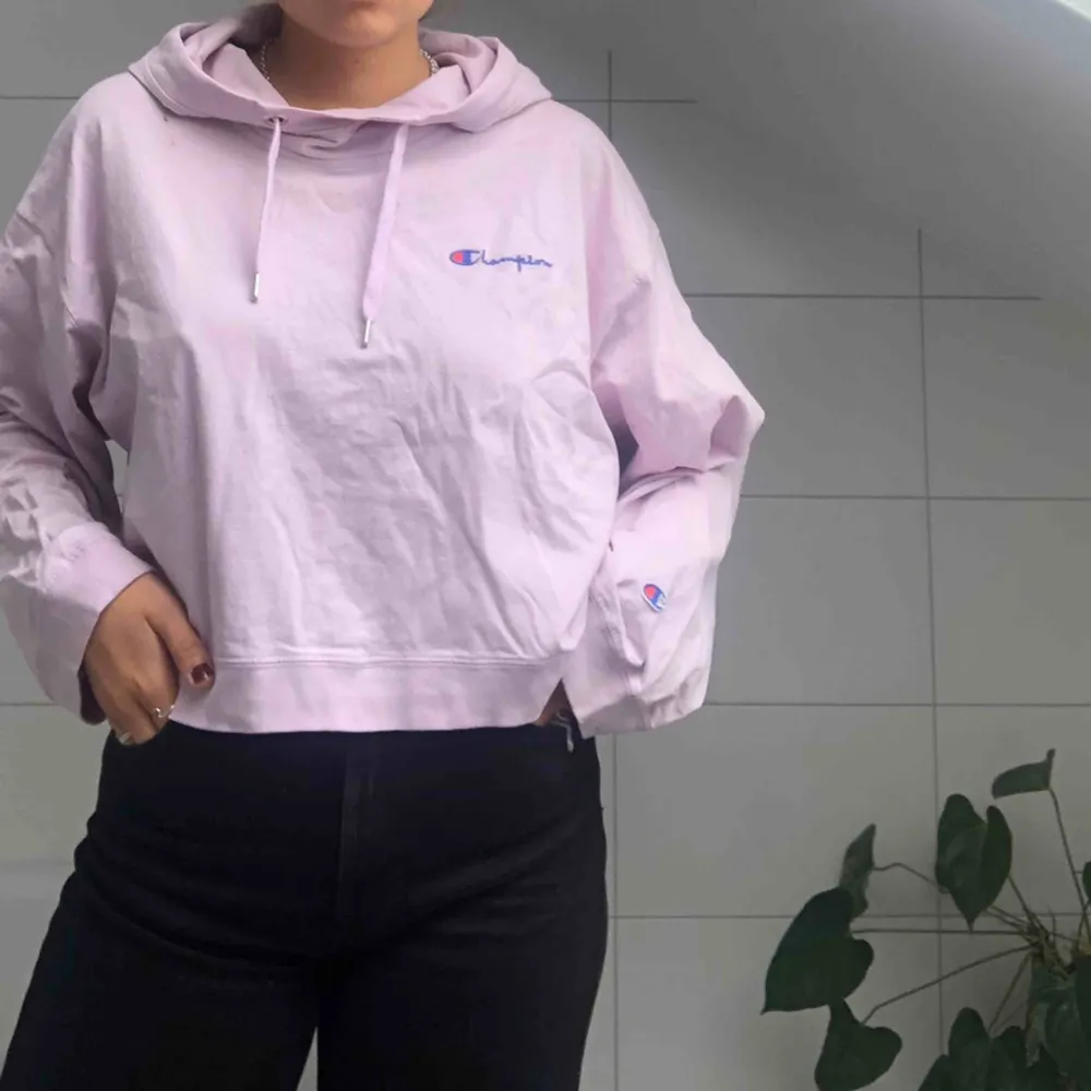 En skitsnygg croppad hoodie från märket Champion. Det är en lila/rosa färg och rätt lös i storleken så passar en m också!. Hoodies.