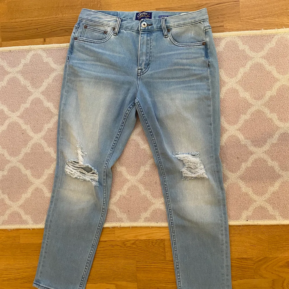 Säljer jeans från Crocker med två hål vid knäna. Storlek W 27, säljer dom för 120kr med gratis frakt. Jeans & Byxor.