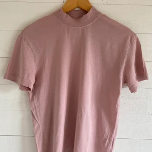 And other stories - t-shirt  - En t-shirt från & Other Stories i en rosa/mauve ton. Har en turtle neck-krage. Originalpris: 300 kr