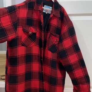 Skjortjacka  - Rutig skjortjacka i röd och svart. Säljer pga. Använder aldrig. Köpt på second hand för 500kr, använd en gång sedan dess. Är en M men är oversize! Skulle säga att det är en L/XL i storleken men väldigt fin oversize. Mer bilder kan skickas! 