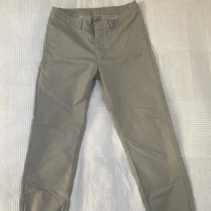 Lågmidjade Tiger of Sweden kostymbyxor - Grå/beige lågmidjade kostymbyxor från tiger of sweden. Köpta för 1500:- på NK och är varsamt använda. Säljs då dom inte passar mig längre. Kan mötas upp i Stockholm annars kostar frakt 44:- 💙💙  Storlek 34.