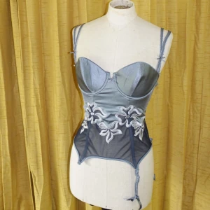 Bustier/korsett - Vääärldens finaste med strumpebandshållare. Ett av banden har tyvärr trillat av, därav reducerat pris, annars felfri. Frakt ingår i priset, självklart oanvänt.