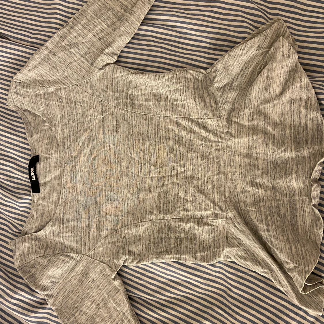 Grå tröja med ”volanger” ner till