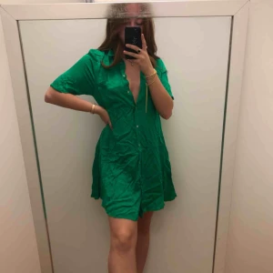  - Superfin grön klänning i satinaktigt tyg. Använd 2ggr. Säljer för använder den så sällan. Vill man ha tajtare i midjan så är den superfin med ett skärp som jag håller med handen på första bilden. Frakt ingår i priset✨