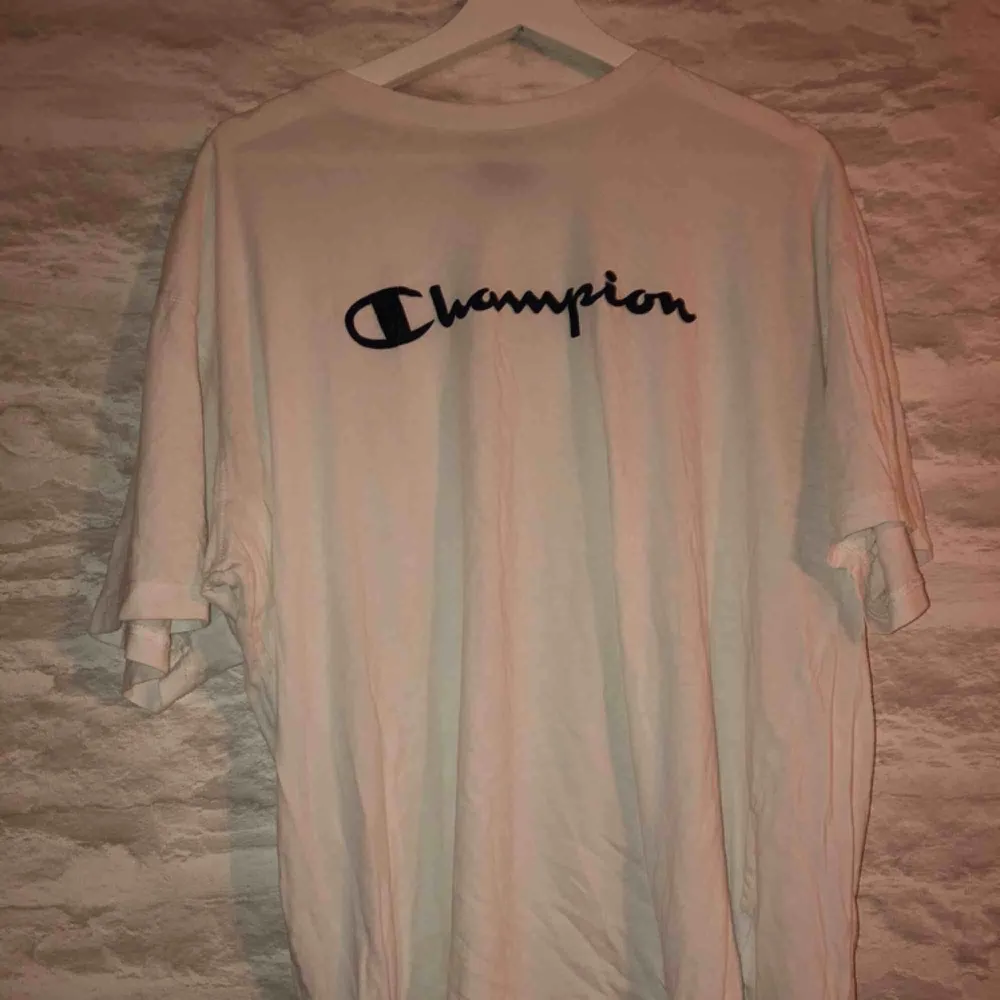 Vit champion t-shirt i storleken XXL men sitter som en L. Köparen står för frakten.. T-shirts.