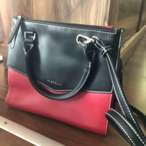  - Väldigt fin och cool röd och svart handväska från fiorelli  Kör för ca 400-500kr  Kan mötas i nacka eller i slussen! Om köparen vill ha väskan skickad till sig står köparen för frakten  Betalning sker via swish