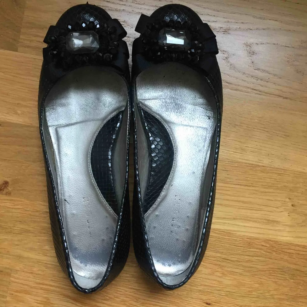 Söta svarta läderballerinor med ormskinnseffekt. Har används väldigt få antal gånger. I storlek 36.. Skor.