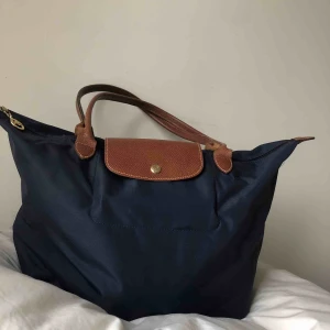  - Marinblå väska från Longchamp med guld detaljer. Tror detta är deras ”mellan-storlek”   Kan hämtas i uppsala eller skickas mot fraktkostnad🌟 