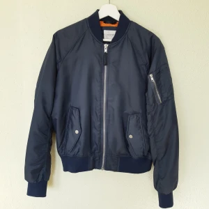 Bomberjacka - Mörkblå VALIENT bomberjacka med orange fodring. Perfekt för våren. Nypris 350kr. Lite nopprig i kragen.
