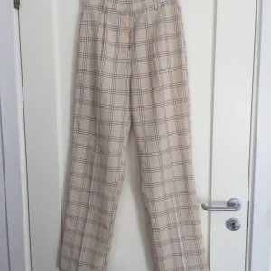 Rutiga byxor - Beigea rutiga byxor från NA-KD i storlek 34 :) Köparen betalar frakt.