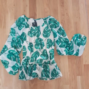 Somrig topp med bladmönster - Topp med resår i midjan och ärmarna, fint mönster av blad. Säljes pga lite för liten för mig! 