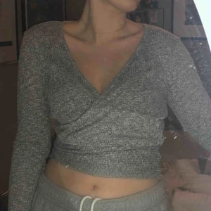  - Grå wrap top från Nelly.com i perfekt skick. Aldrig använd. Frakt tillkommer 