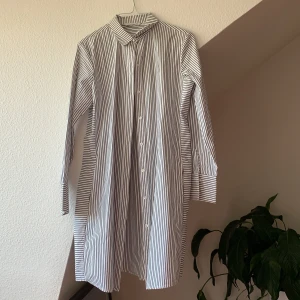 Randig skjorta  - Längre randig skjorta i mycket bra skick. Använd ett fåtal gånger. Säljer för att den blivit för liten för mig. 