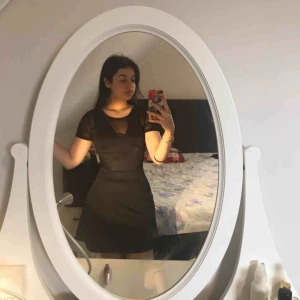  - Svart klänning med tyget mesh på vissa områden (precis över brösten och även vid midjan). Jätteskön klänning som är väldigt classy.