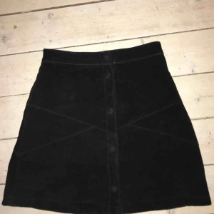  - Superfin kjol i äkta mocka-material, med knappar. 