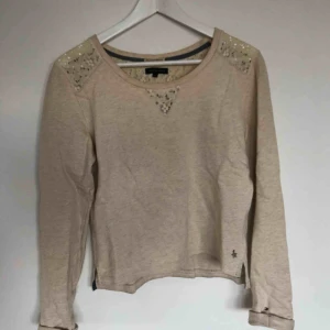  - En krämvit tröja med spetsdetaljer från Tommy Hilfiger, storlek 176.