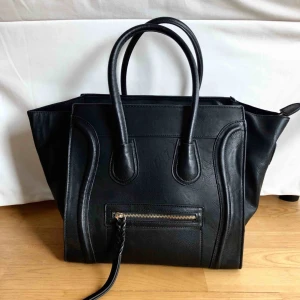  - Snygg svart handväska som går att göra större och mindre! Fodret inuti är sammet! 