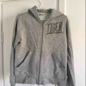  - Grå hoodie från Tiger of Sweden. Den är ganska urtvättad.