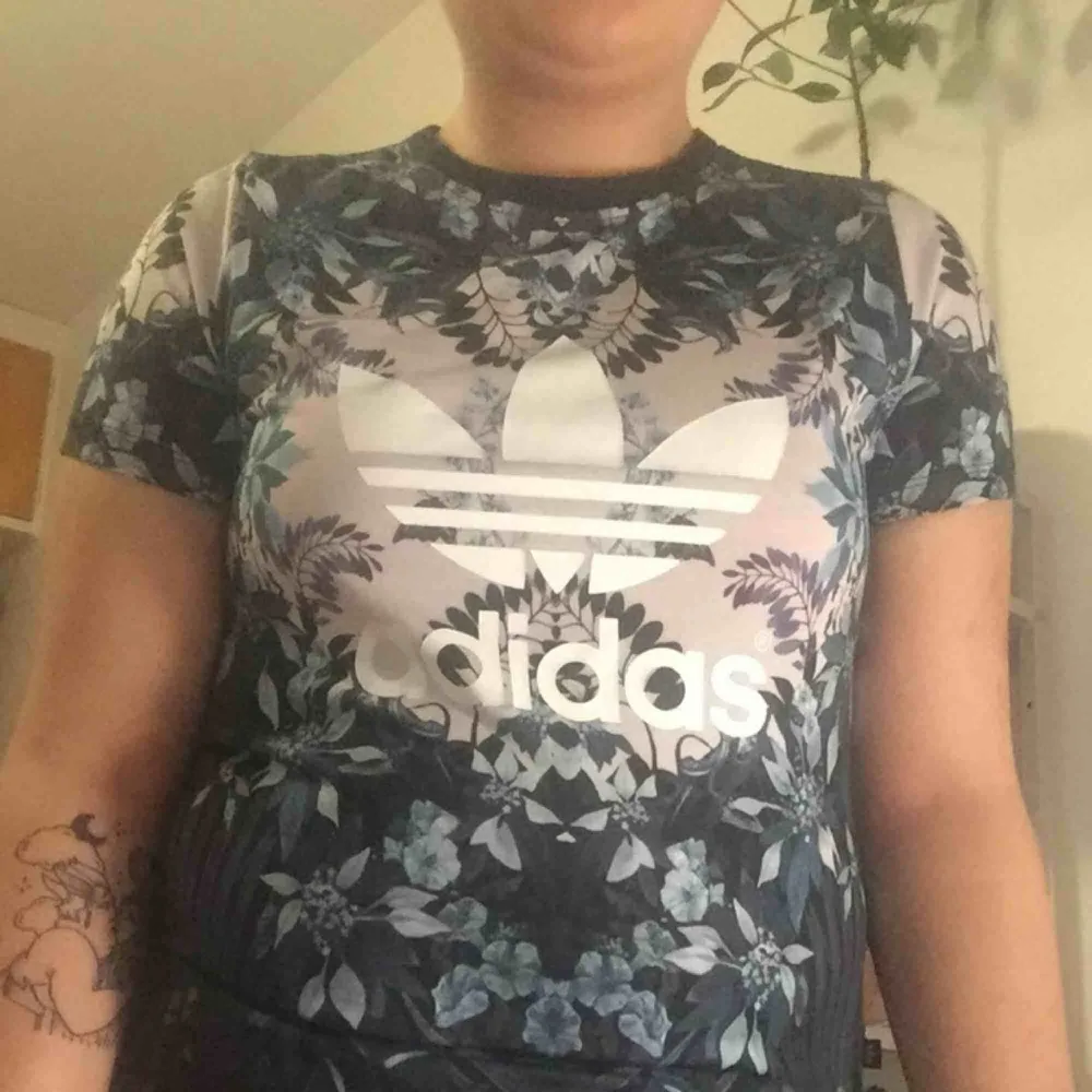 ADIDAS-tshirt med asnajs blommigt tryck.  100%polyester 100%snygg. T-shirts.