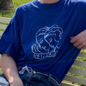 Vintage ljusblå t-shirt med nytryckt design!               SAMSARA köper in secondhand kläder som inte blir sålda och revitaliserar dem med unika och högkvalitativa tryck. Varje plagg sparar cirka 2400L vatten och 1,4 kg co2!   Modellen är 190cm! 