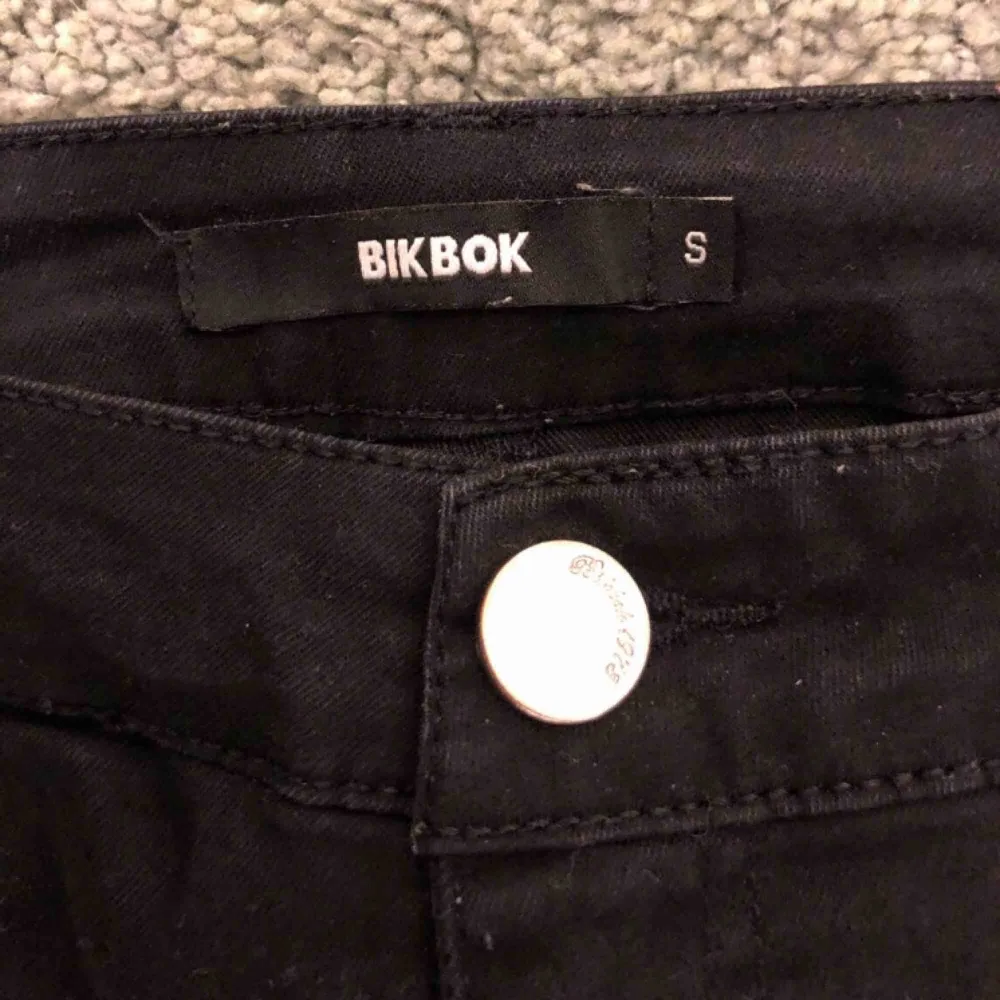 Nästan helt oanvända svarta bootcut byxor från BikBok, storlek S och har hål på knäna. Nypris:599kr  Köparen står för frakten!. Jeans & Byxor.