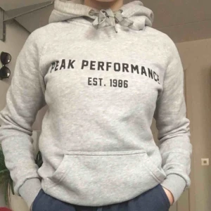 - Grå hoddie från PeakPerformance med text. Bekväm och snygg. Använd men känns som ny då kvaliteten är väldigt bra, dock sitter några av bokstäverna lite löst vid kanterna men inte så att de kommer trilla av eller så att man märker✨✨