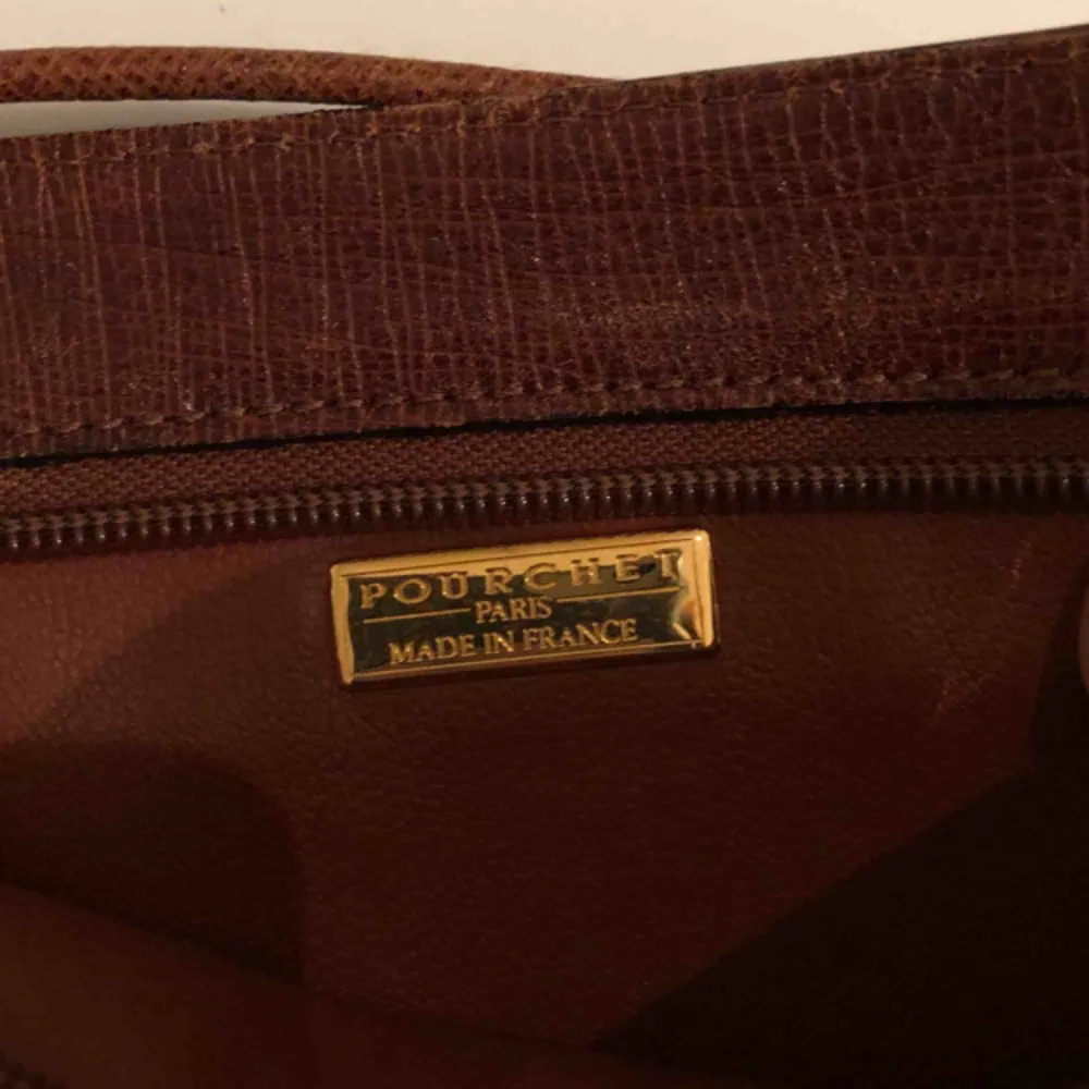 Vintage mindre handväska i brunt läder från Pourchet Paris (Made in France). Gulddetaljer och i fint skick!. Accessoarer.