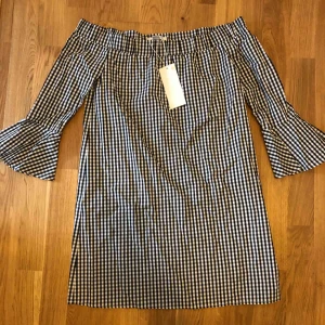  - Oanvänd off shoulder klänning m volang i ärmslut