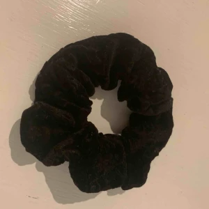  - Svart tofs, scrunchie. Sammetstyg med blommönster i svart. Frakt 9kr. Nytvättad. 