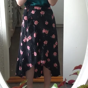 Blommig kjol från HM! - Superfin omlottkjol från HM! Längre i bak och volang nere på klänningen. Skriv för fler bilder! Helt oanvänd.