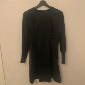 Klänning från Gina Tricot - Helt oanvänd klänning från Gina Tricot. Jättefint och skönt material. Knappar vid ärmarna. Storlek 34. Frakt tillkommer💋