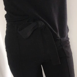  - Kostymbyxor från VILA. Svarta med pressveck fram. Högmidjade med knytband i midjan (och gylf). Ankellånga, på mig som är 165.