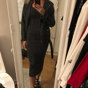  - Snygg tight svart klistrig klänning köpt o London. Oanvänd 