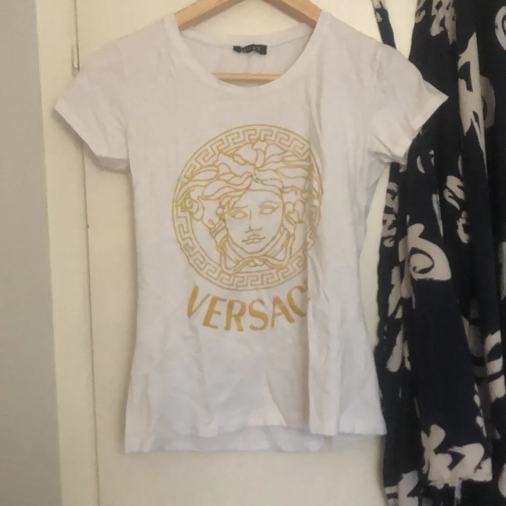 Såå fin Versace t-shirt med guldigt märke. Skrynklig eftersom den legat i en låda ett tag. Helt oanvänd av mig. Står stl L men skulle säga S. Väldigt stretchig dock så funkar lika bra för Xs och M. 🥰🥰 troligtvist inte äkta, men ingen skillnad! . T-shirts.