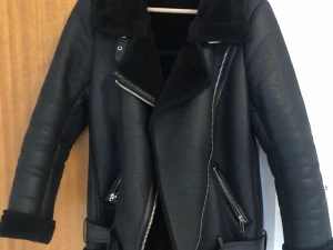 Zara skinnjacka - Säljer denna superfina fodrade skinnjacka/aviator jacka då den tyvärr inte kommer till användning. Har inga defekter förutom att en läderrem man kan hänga upp jackan med har lossnat, men det är lättfixat. Dessutom funkar tygremmen lika bra för att hänga upp den💞 Strl XS, passar mig som har XS-S