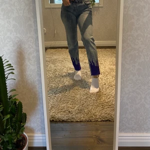 Jeans med lila eldflammor längst ner - Eldflammorna är ritade med färg som ska hålla i tvätten!