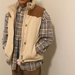 Boomerang Beige Dunväst Strl: L - En underbar, jättevarm men superlätt beige dunväst från Boomerang med brun mockadetalj på axlarna. Använd ett par gånger men är annars i topp skick. Säljer för att jag rensar garderoben. Köparen står för frakt, mötesplats kan diskuteras😚✌🏽