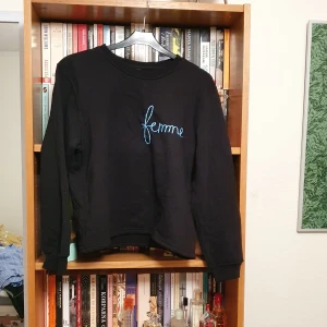 Svart collegetröja med broderi - En svart collegetröja. Köpt på Beyond retro men har inga tags. Uppskattar den till storlek S. Är väldigt mjuk på insidan. Blå broderi med texten "Femme" på vänster sida. Köparen betalar frakten och betalning sker via swish