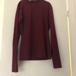 Tunn polotröja - Tunn vinröd polotröja i bra skick med ”Poison” broderat på kragen. Märkt storlek M men känns mer som en S.  (Finns upplagd på flera sidor)