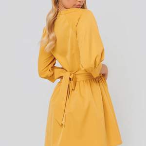 Fin gul klänning från NA-KD i storlek 36. Knappar framtill, fint åtsittande i midjan med ett bälte som kan knytas fram eller bak! Klänningen är helt oanvänd med prislapparna kvar och säljs pga att den blivit för stor. 💔