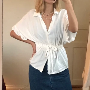 Vit blus - Skön blus med ett strechigt skärp som knyts i midjan. Bra skick. Skriv om du har frågor💘