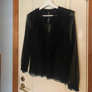  - Underbar blus i transparent tyg med fina detaljer som små knappar och volanger. Använd vid ett fåtal tillfällen. Köpt på Zara i New York. Kan skicka bilder på hur blusen ser ut på om så önskas! ❣️