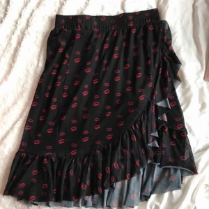  - Svart kjol med pussmuns mönster i bra skick 