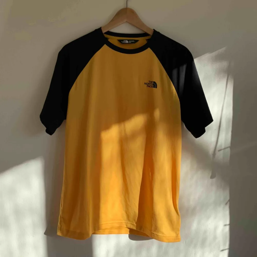 En gul & svart north face tshirt! Skönt material, logga fram & bak. Använd 1 gång, därav i nyskick 🌟. T-shirts.