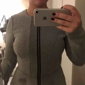  - En grå kofta, en större volang ner till som markerar midjan snyggt, inte min stil längre o använd fåtal gånger💓 super najs och stilren  60kr