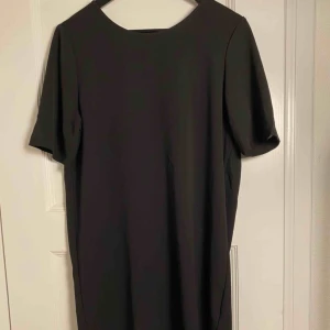  - Svart miniklänning / knälång. Knappt använd. Crêpat material. Köparen står för frakten. 