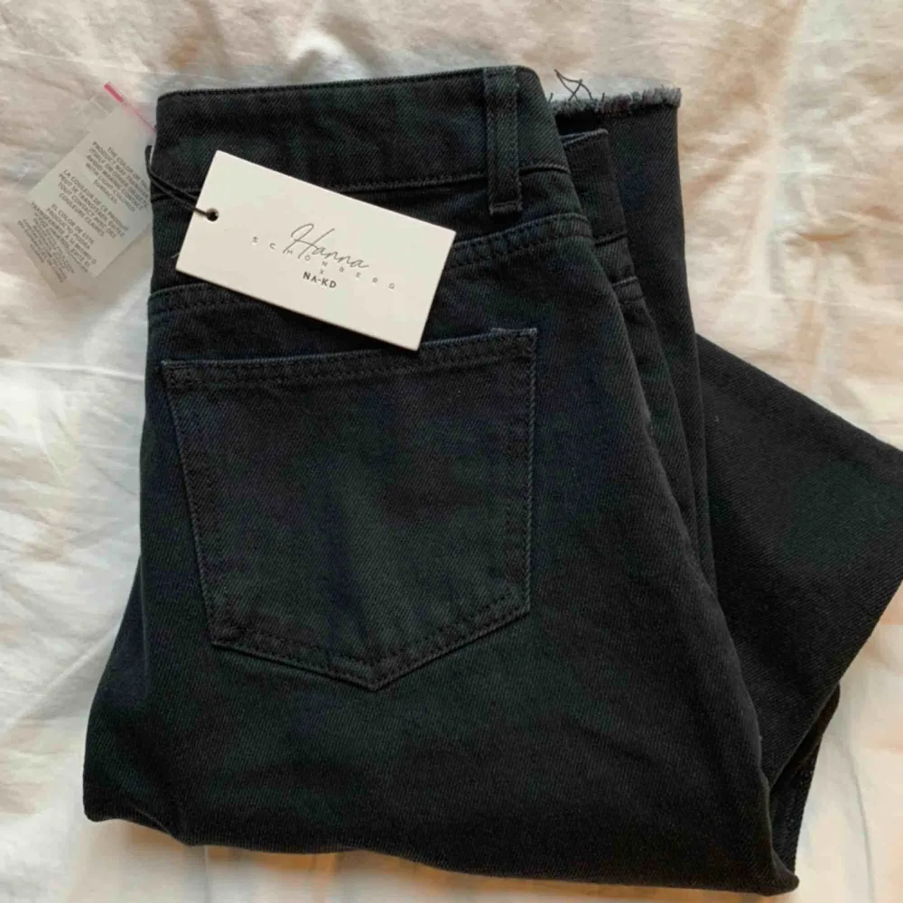 Säljer dessa oanvända jeans från Hanna Schönberg x NA-KD. Skitsnygga svarta jeans med slits på varje sida samt slitningar nedtill. Säljs då dem tyvärr är för korta för mig (jag är ca 175 cm lång)  Kom gärna med bud (frakt ligger på 66 kr) . Jeans & Byxor.
