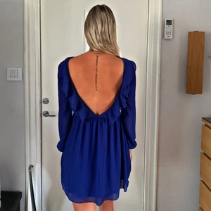 Blå klänning med öppen rygg - Blå klänning ifrån Nelly, använd endast en kväll. Så den är som ny, inga skador eller något trasigt. Frakt tillkommer