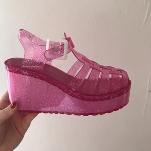  - Så kallade Jelly sandels med platå, rosa med glitter. Kan vara lite små i storleken, men perfekta för dig som vill ha nått som sticker ut eller passar på rave. En riktig trowback till 90talet!  Köparen betalar för frakten. 
